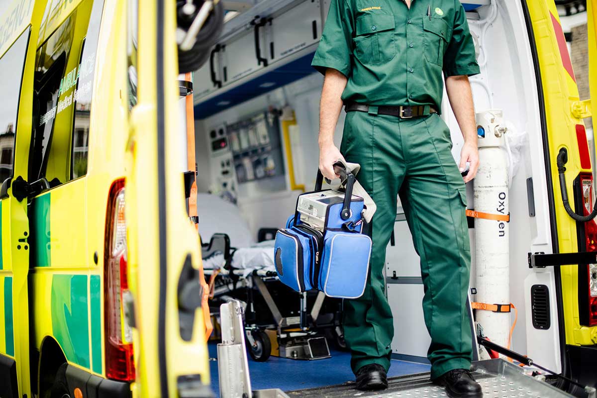 An in-action shot of an ambulance crew member wearing their green uniform