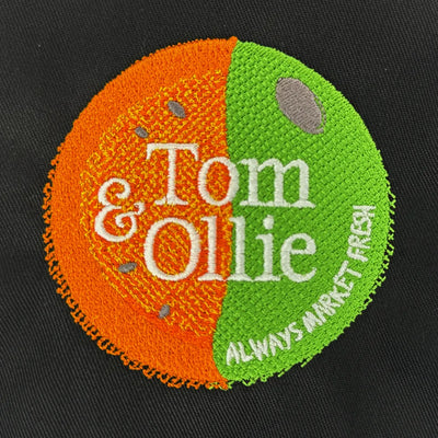 Embroidered patch with 'Tom & Ollie' branding on a black background
