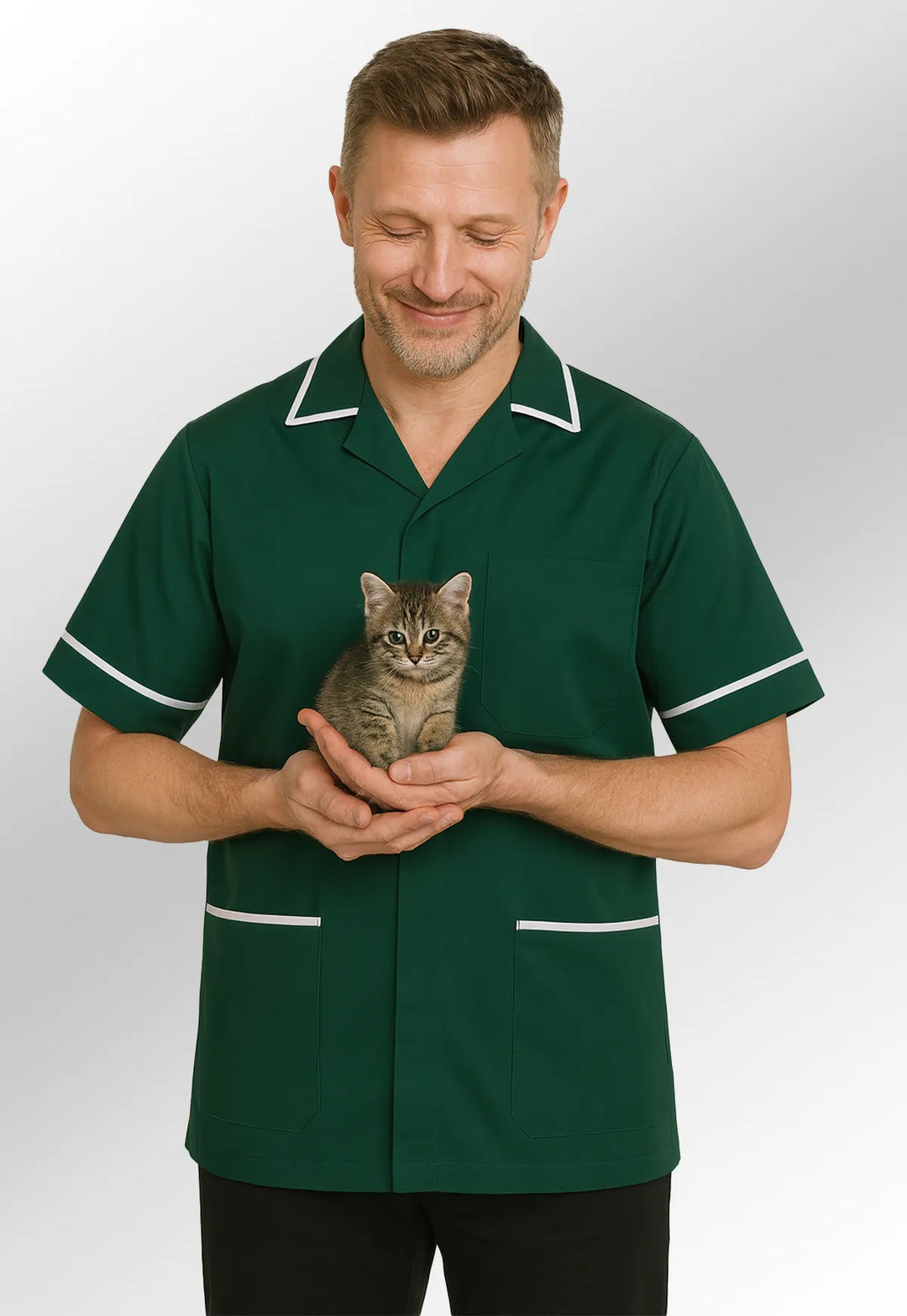 Vet wearing a bottle green tunic holding a small tabby cat