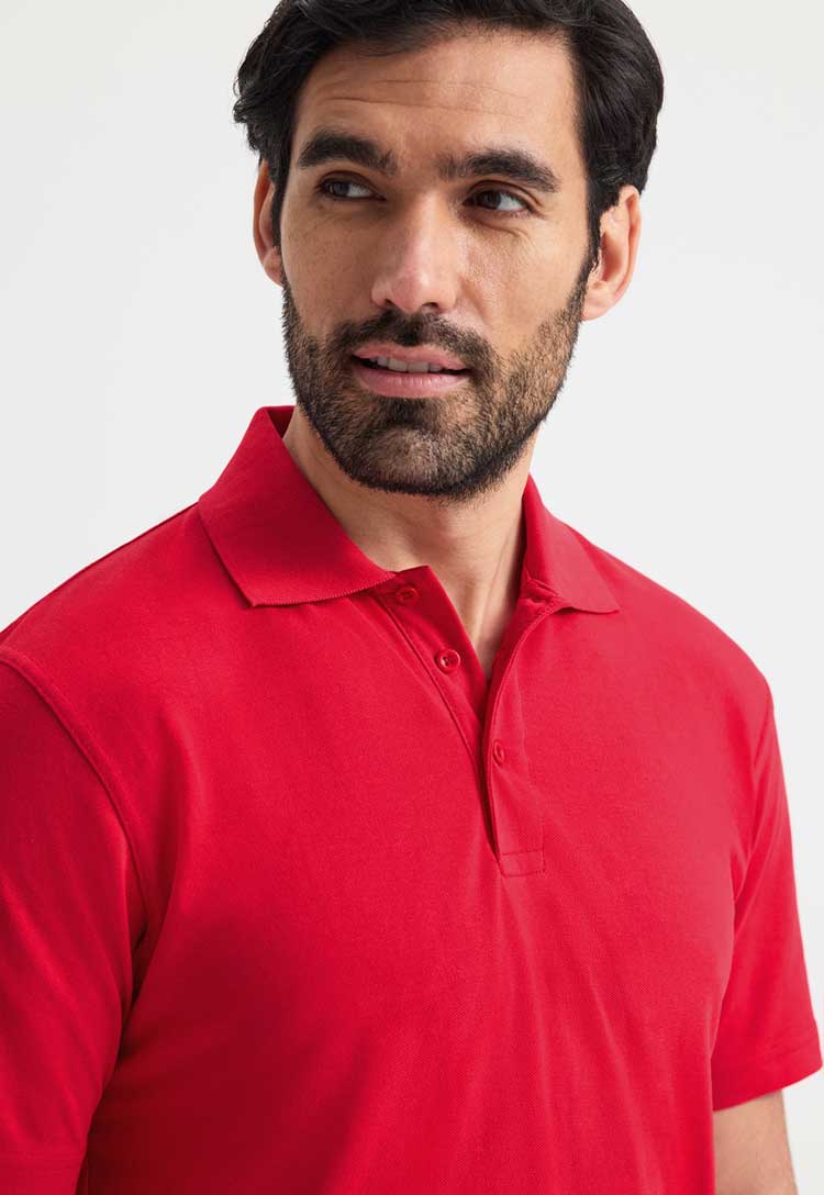 close up of model wearing uneek active polo in red