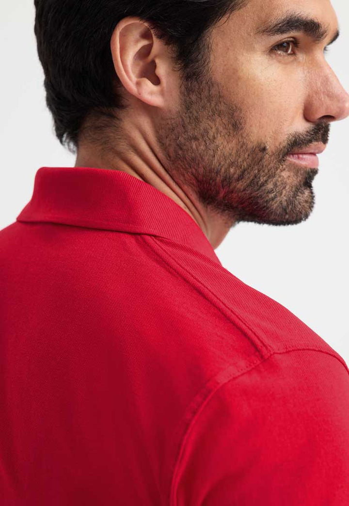 close up back view of model wearing uneek active polo in red