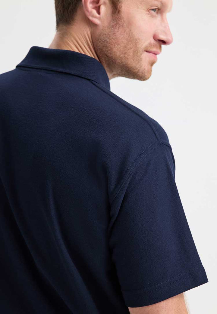 model wearing classic polo from uneek in navy shoulder close up