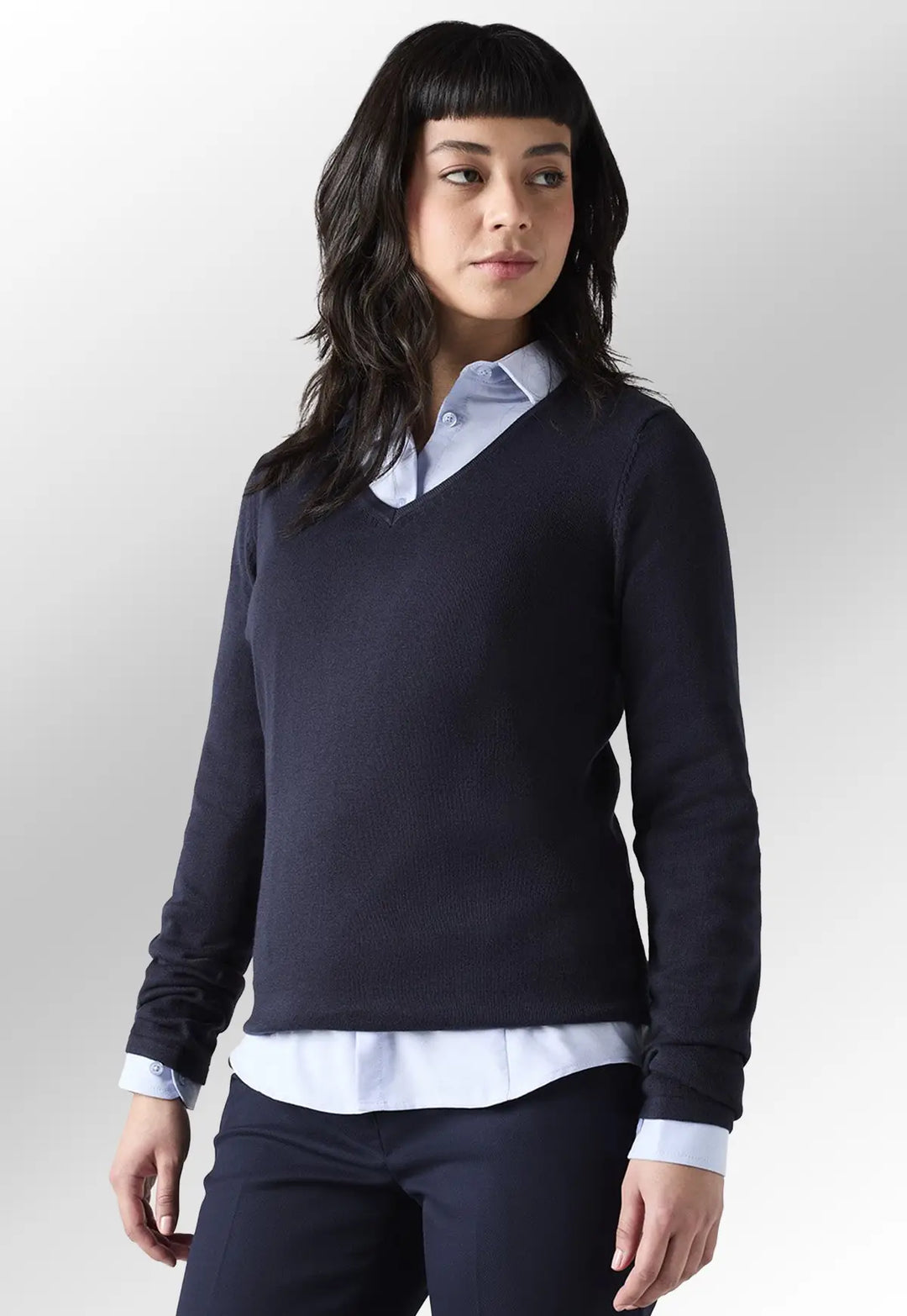 Model wearing the Henbury Women's 12 Gauge V Neck Jumper in Navy paired with a collared shirt.