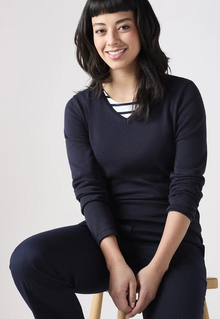 Lifestyle photo of model wearing the Henbury Women's 12 Gauge V Neck Jumper in Navy.