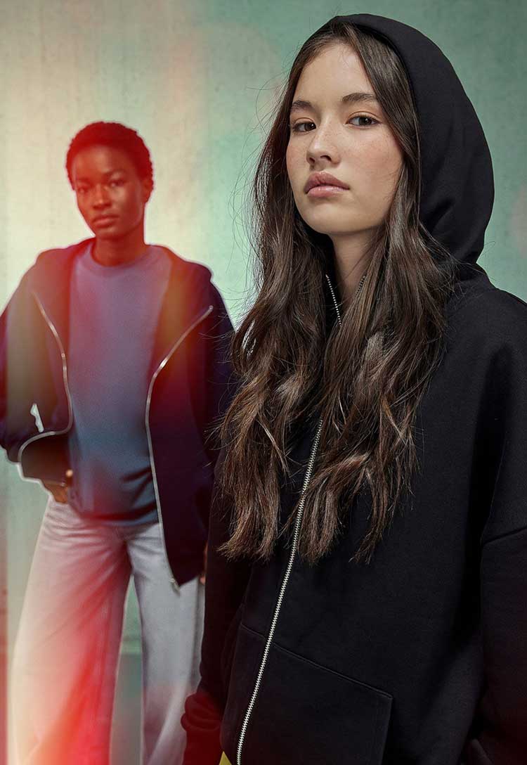 models wearing B&C Influence Zip Hood BA035 in black