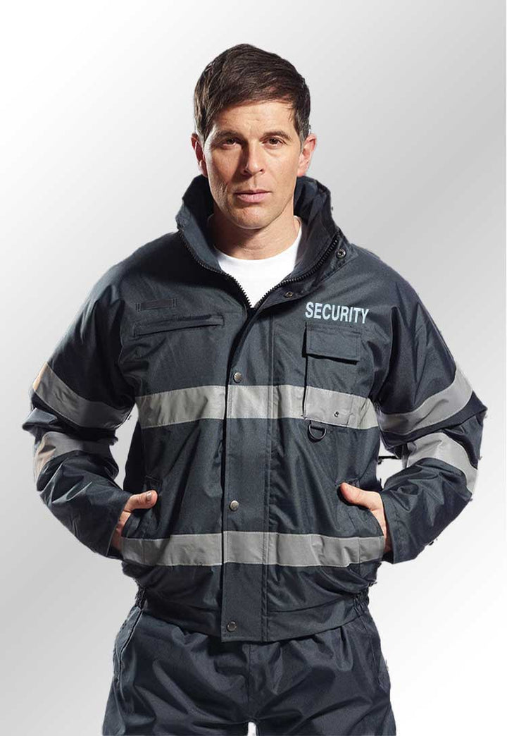 A model wearing a S434 Iona Lite Reflective Bomber Jacket with Security Branding in Navy