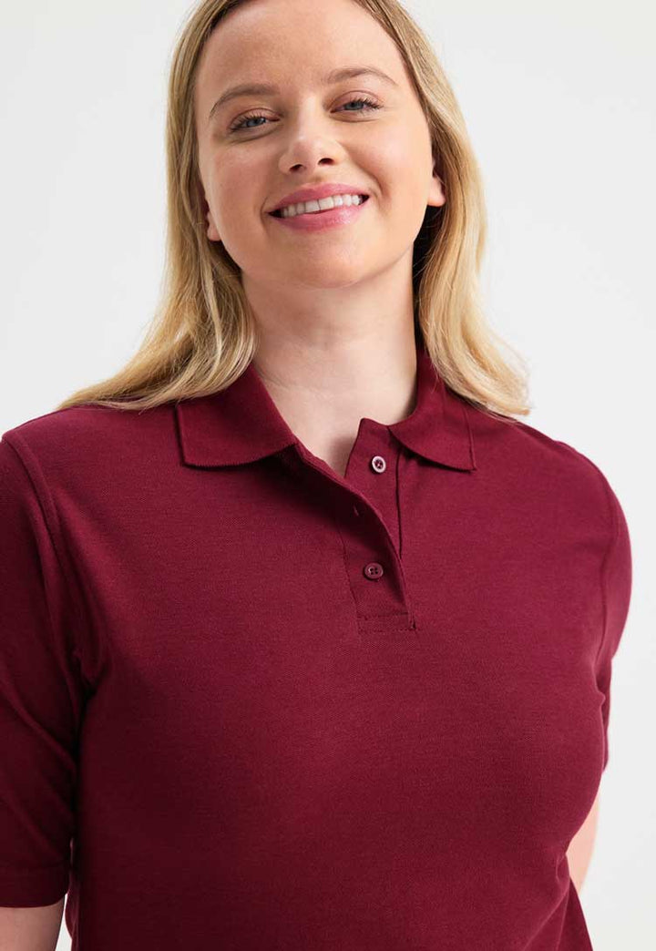 close up of model wearing uneek Ladies Classic Polo Shirt in maroon