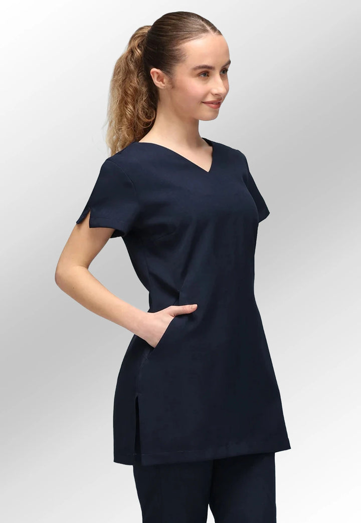 Side view of model wearing the Navy Nina V Neck Salon Tunic with Pockets.