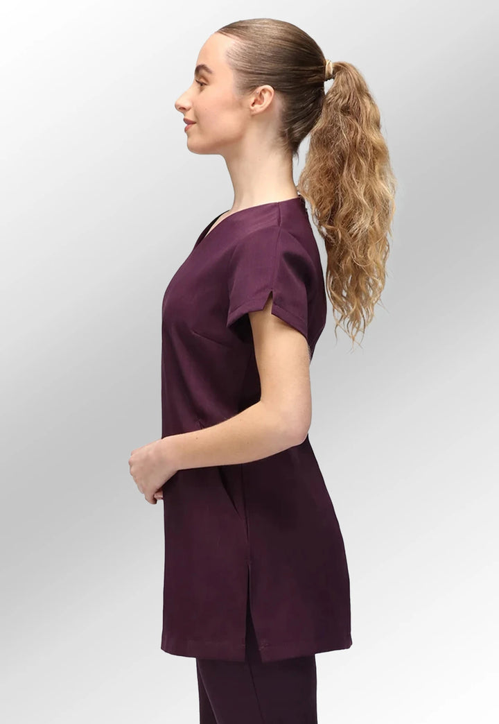 Side view of model wearing the La Beeby Plum Nina V Neck Salon Tunic with Pockets.