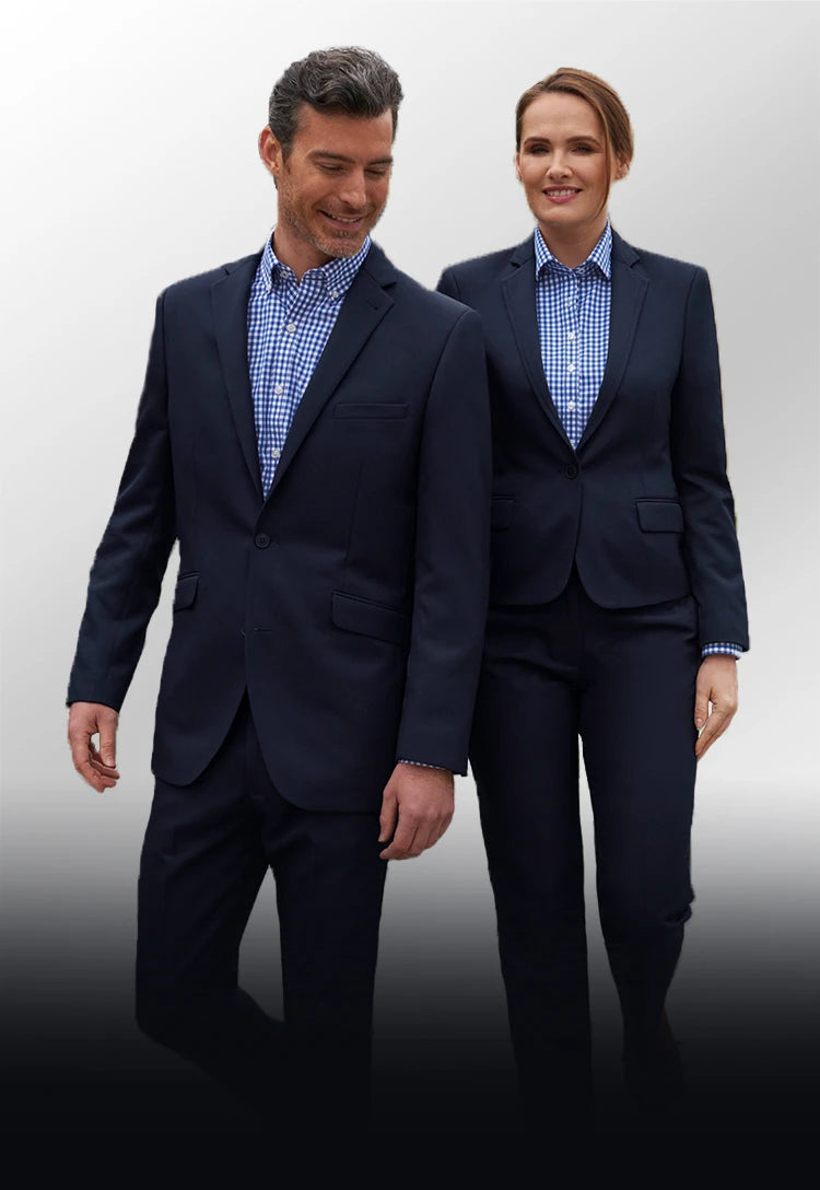 A man and woman wearing matching navy suits with blue checked shirts from Brook Taverner One Collection