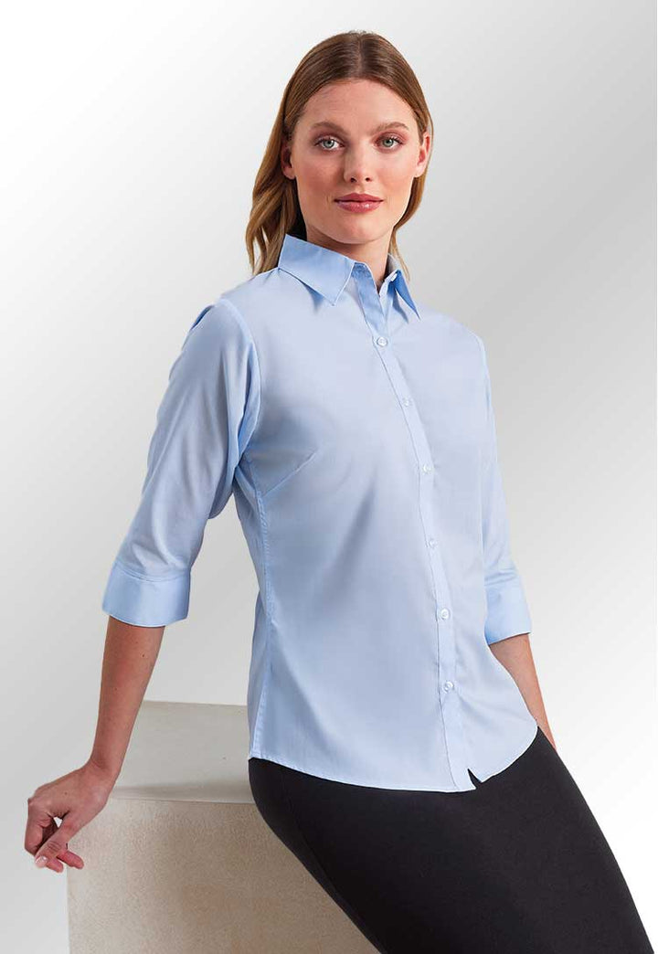 Model wearing the PR305 Women's ¾ sleeve poplin blouse in Light Blue