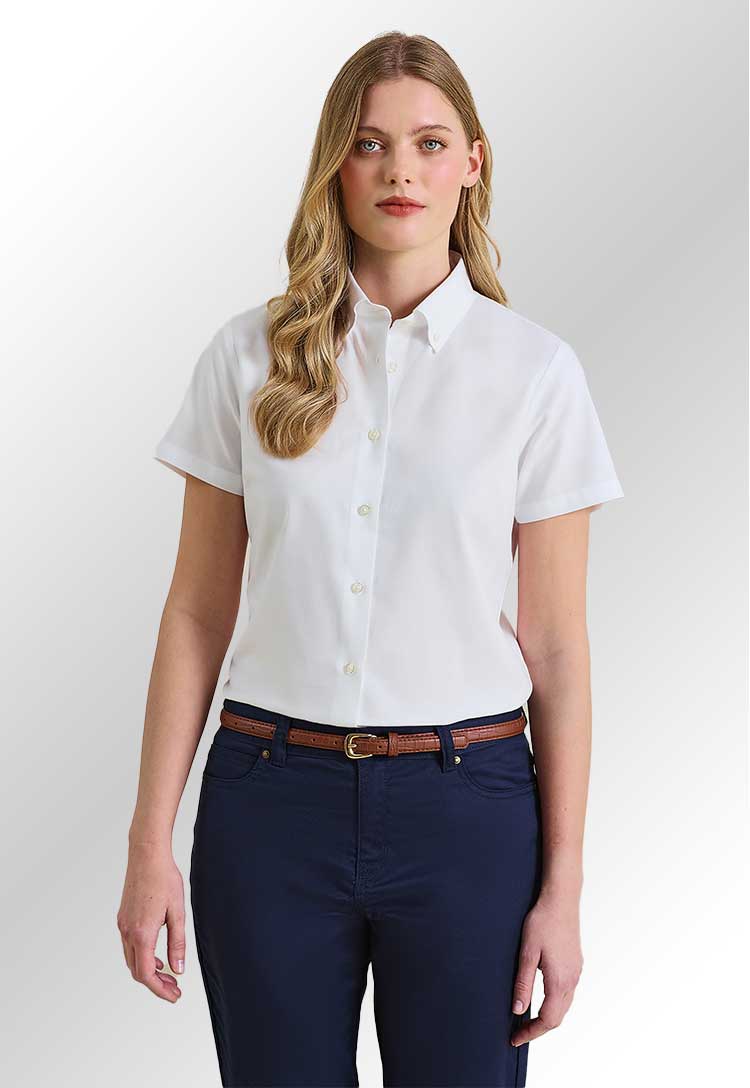 A model wearing a PR386 Womens Supreme Oxford Short Sleeve Shirt in White