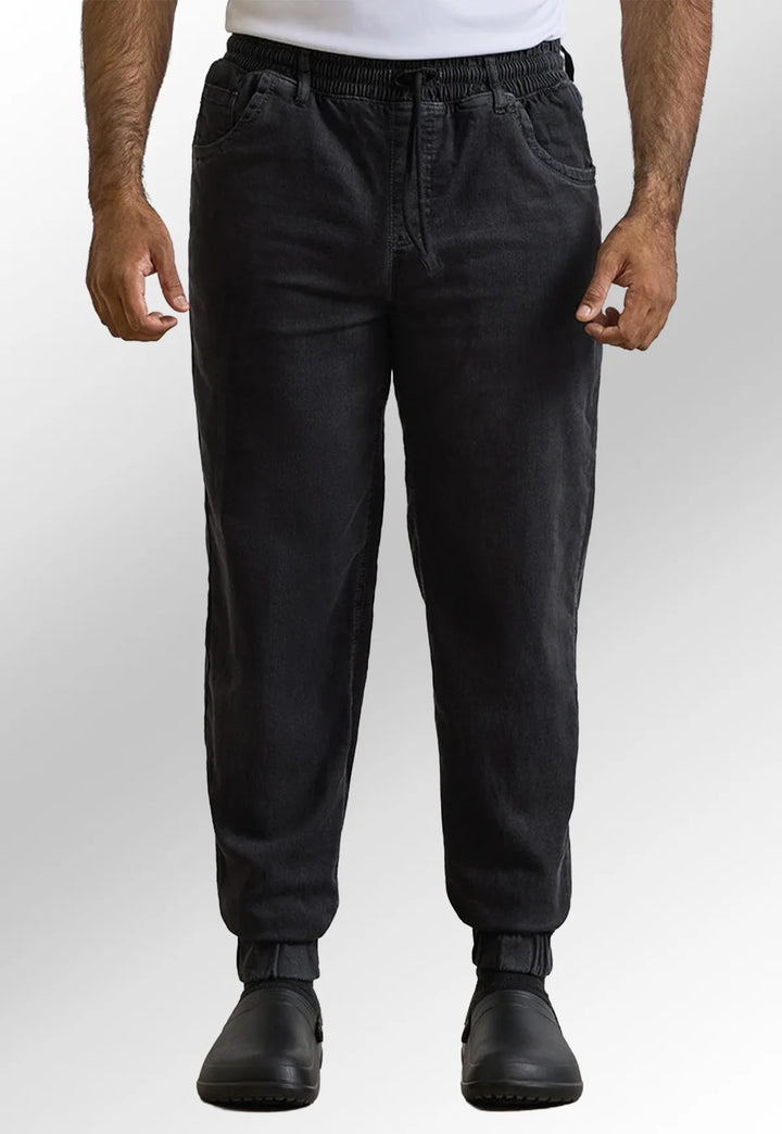 Front view of model wearing the Premier Workwear Chef's Artisan Jogger Bottoms PR556 in Black Denim.