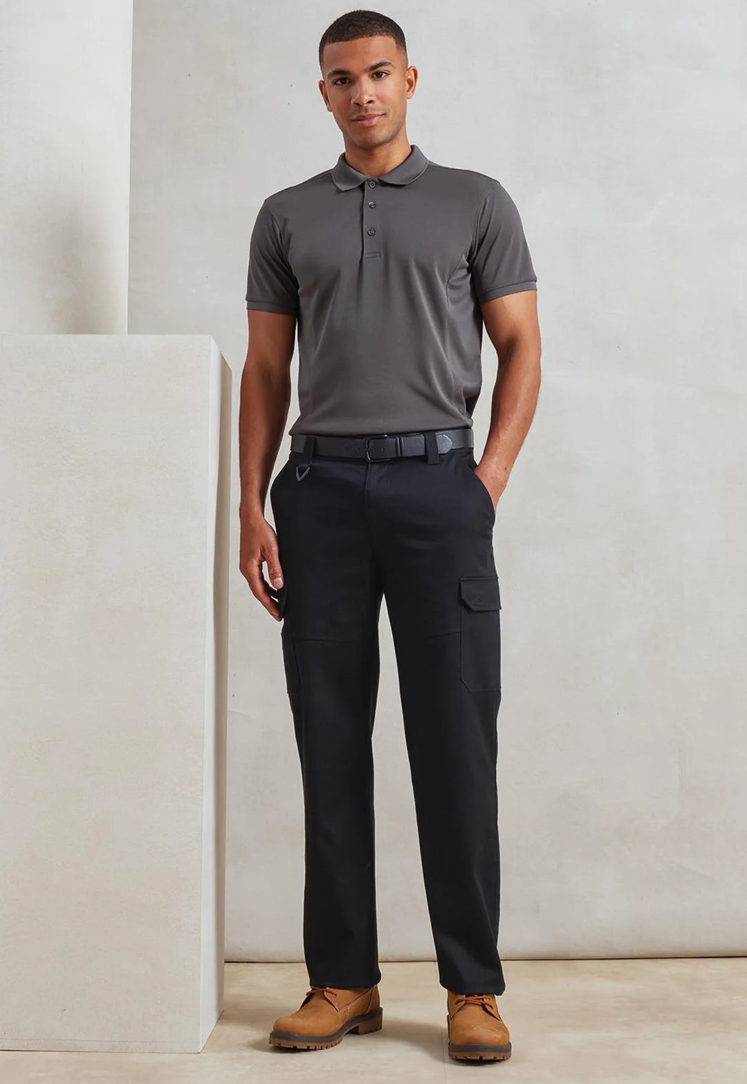 Male model wearing the Premier Stretchchecker Unisex Work Cargo Trousers in Black.
