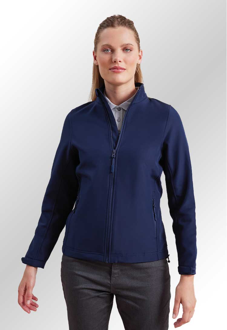 Model wearing a PR812 Women’s Windchecker printable and recycled softshell jacket in Navy