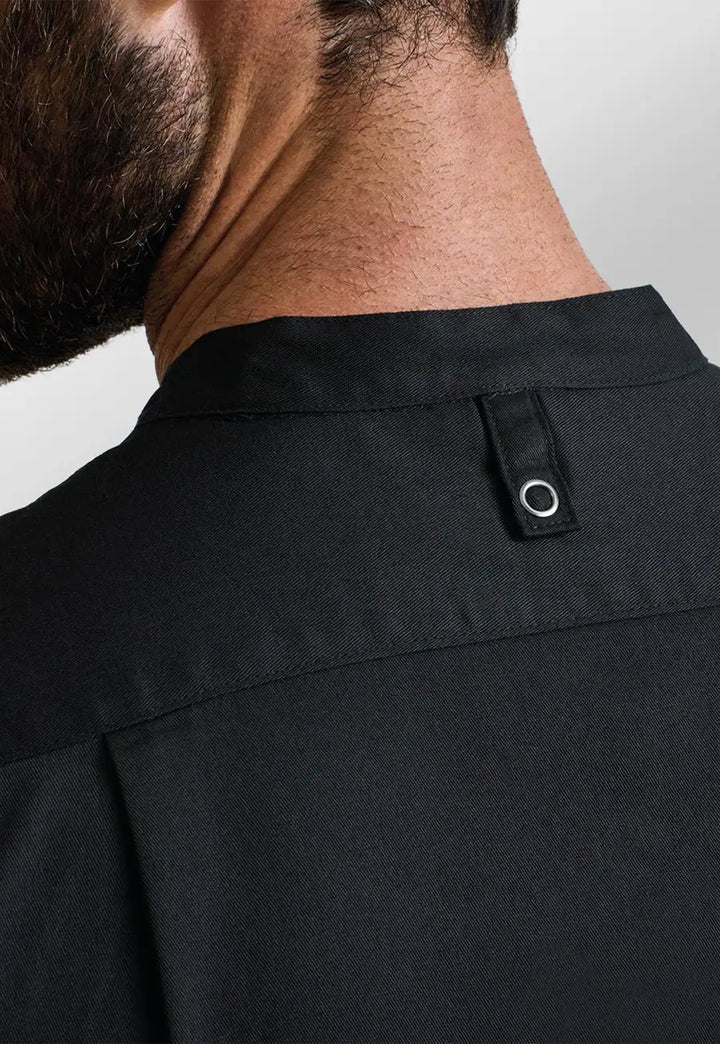 Rear view collar close-up of model wearing the Premier Workwear Chef's 'Recyclight' Short Sleeve Shirt PR904 in Black.