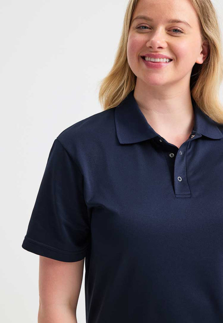 close up of model wearing uneek Processable Polo Shirt  in navy