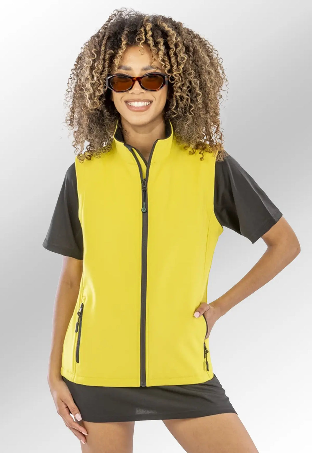 Model wearing the Ladies Printable Softshell Bodywarmer R232F in Black/Yellow.