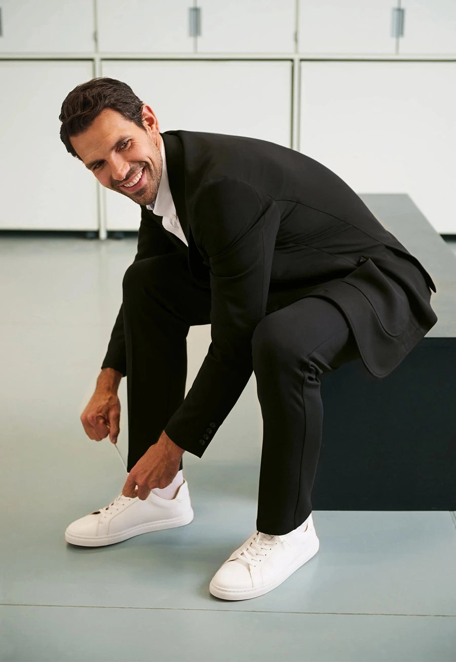 Lifestyle photo of model wearing the Brook Taverner Taurus Jersey Stretch Men's Trousers in Black.