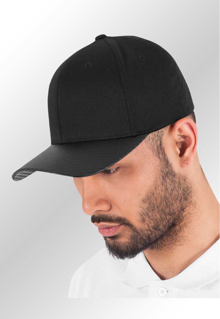 A model wearing the YP103 Carbon Flexfit Cap in Black/Carbon