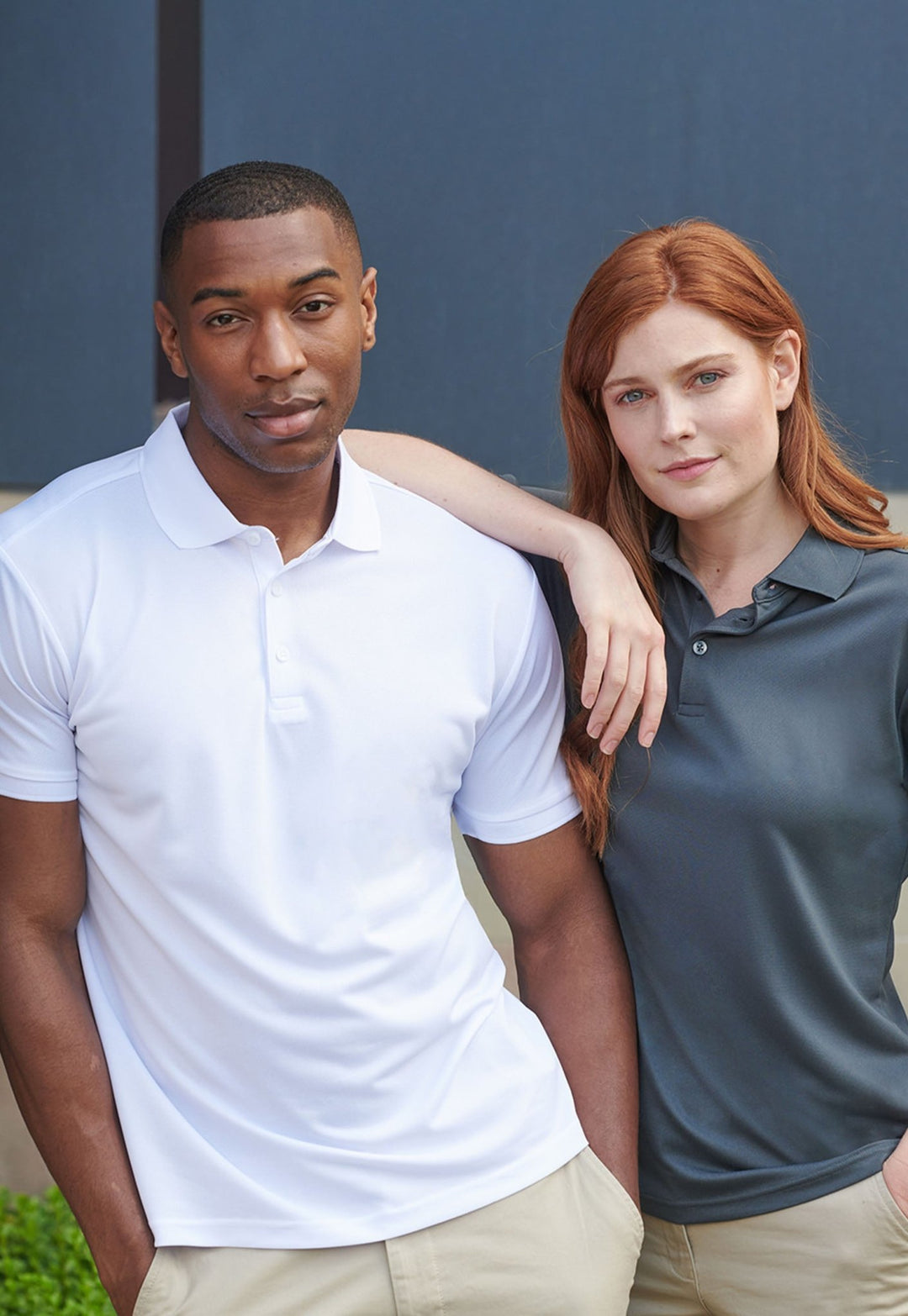 Models Wearing Recycled Polyester Polo Shirts HB465 in White and Charcoal